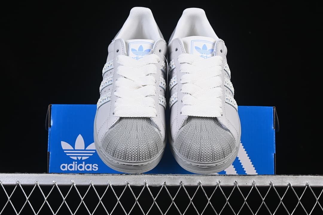 Front view of the pair showing textured shell toes, white laces and pale blue tongue logos.