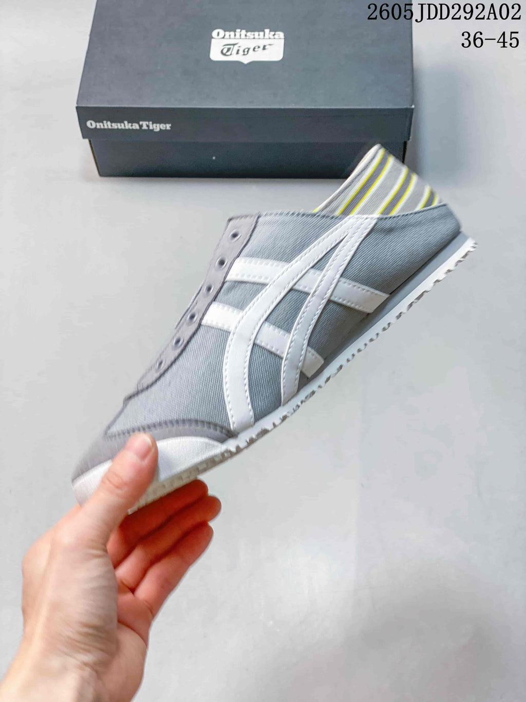 Side view of the gray slip-on sneaker with white side stripes