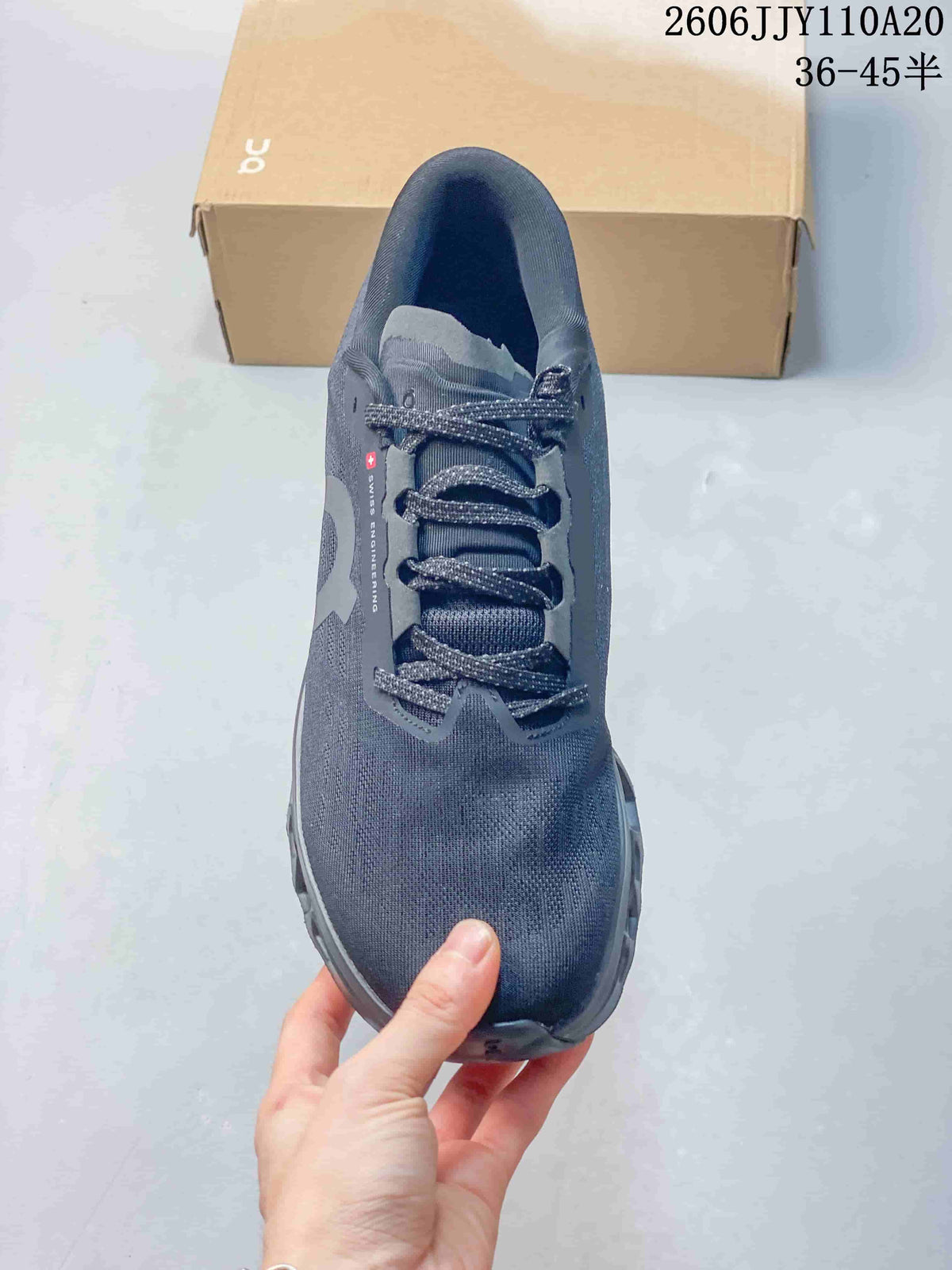 Top view of a dark gray On shoe showing its laces, tongue, and tonal upper.