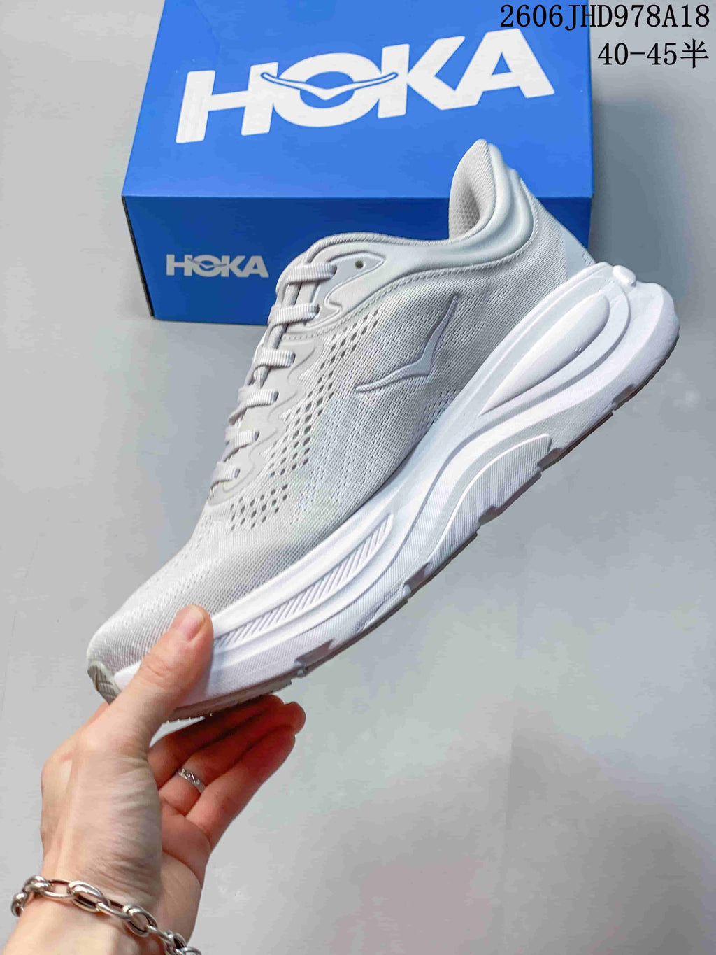 Side profile of a light gray-white HOKA Bondi 9 running shoe
