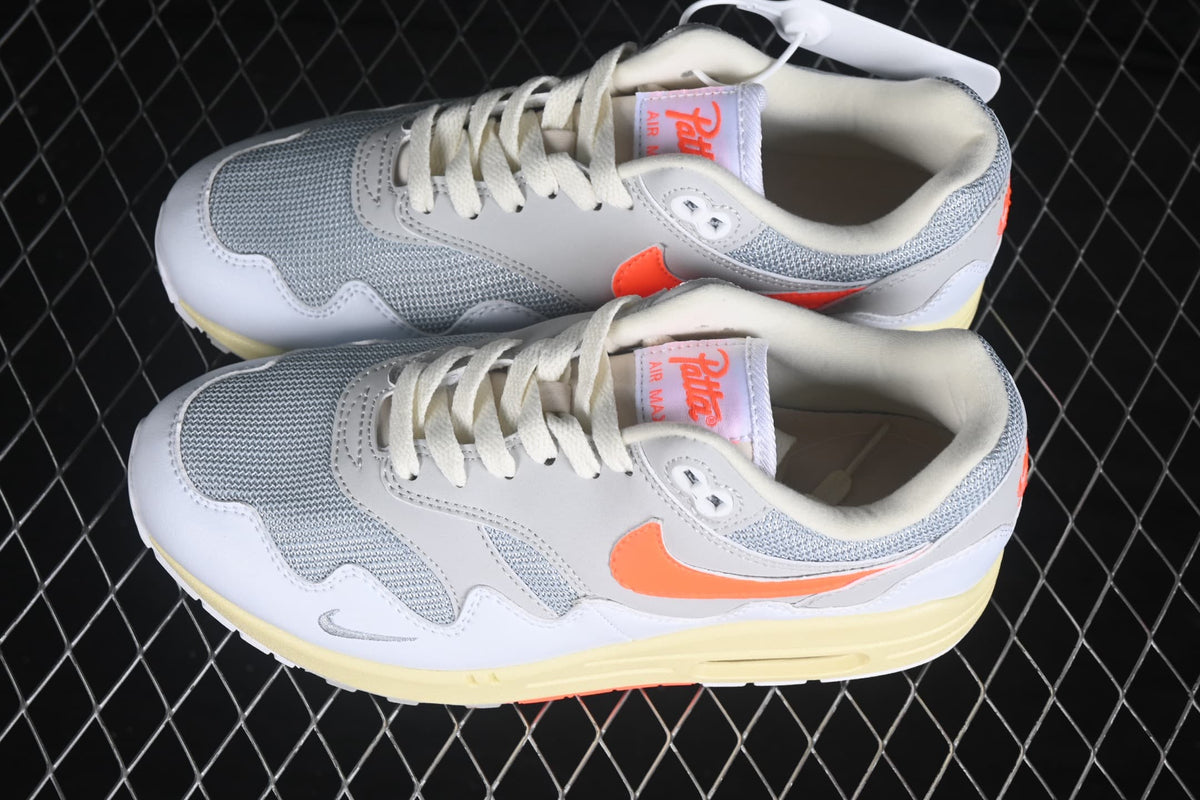 Top-down view of the pair showing grey mesh toe boxes, white laces and orange side branding.