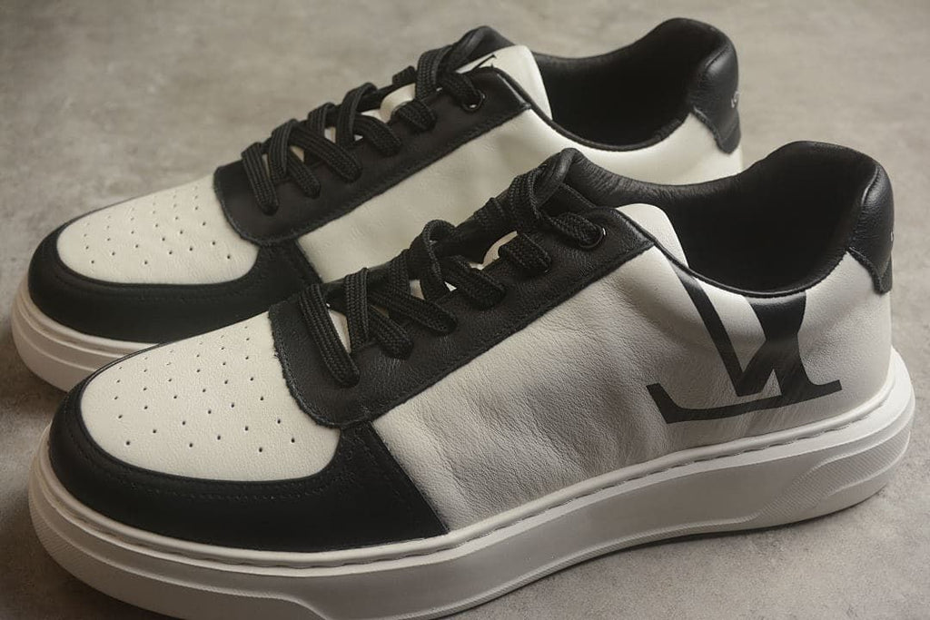 Pair of black-and-white low-top sneakers shown from an angled side view