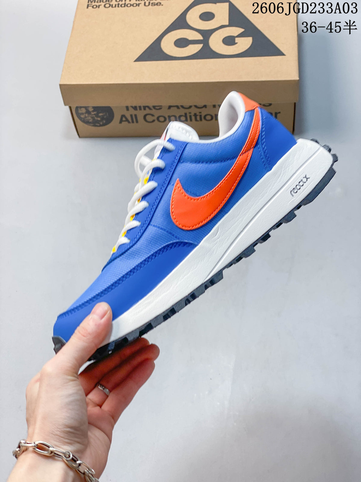 Side view of the blue Nike ACG LDV sneaker with orange Swoosh and white midsole
