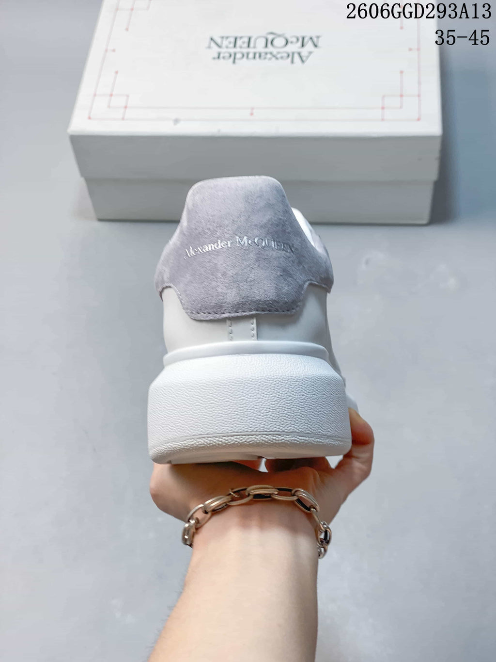 Rear view of a white sneaker with a gray heel panel and thick sole