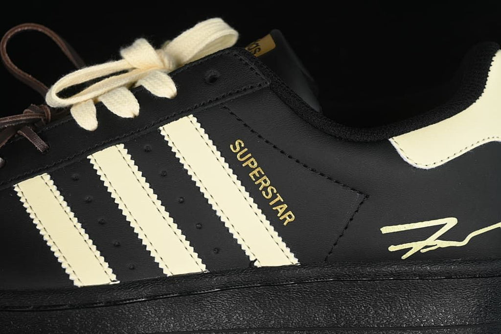 Side detail of the cream stripes, Superstar text, and mixed-color laces.