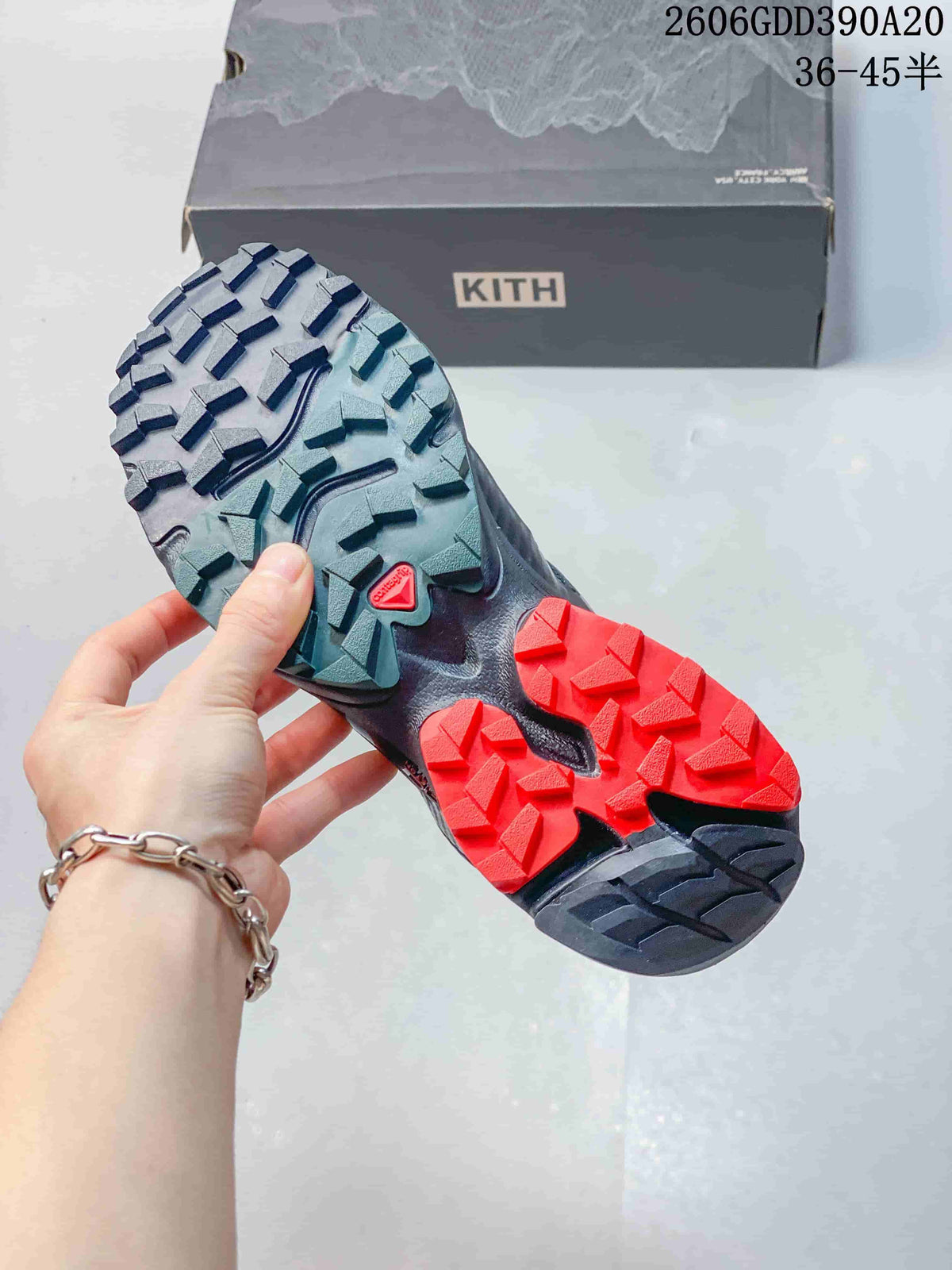 Close-up of the Salomon XT-4K shoe outsole with angular tread and red and teal sections.