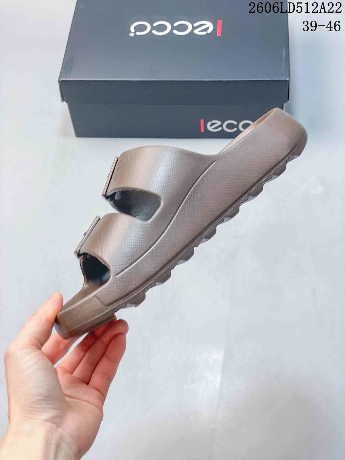 Side profile of the taupe slide sandal with two buckle straps.