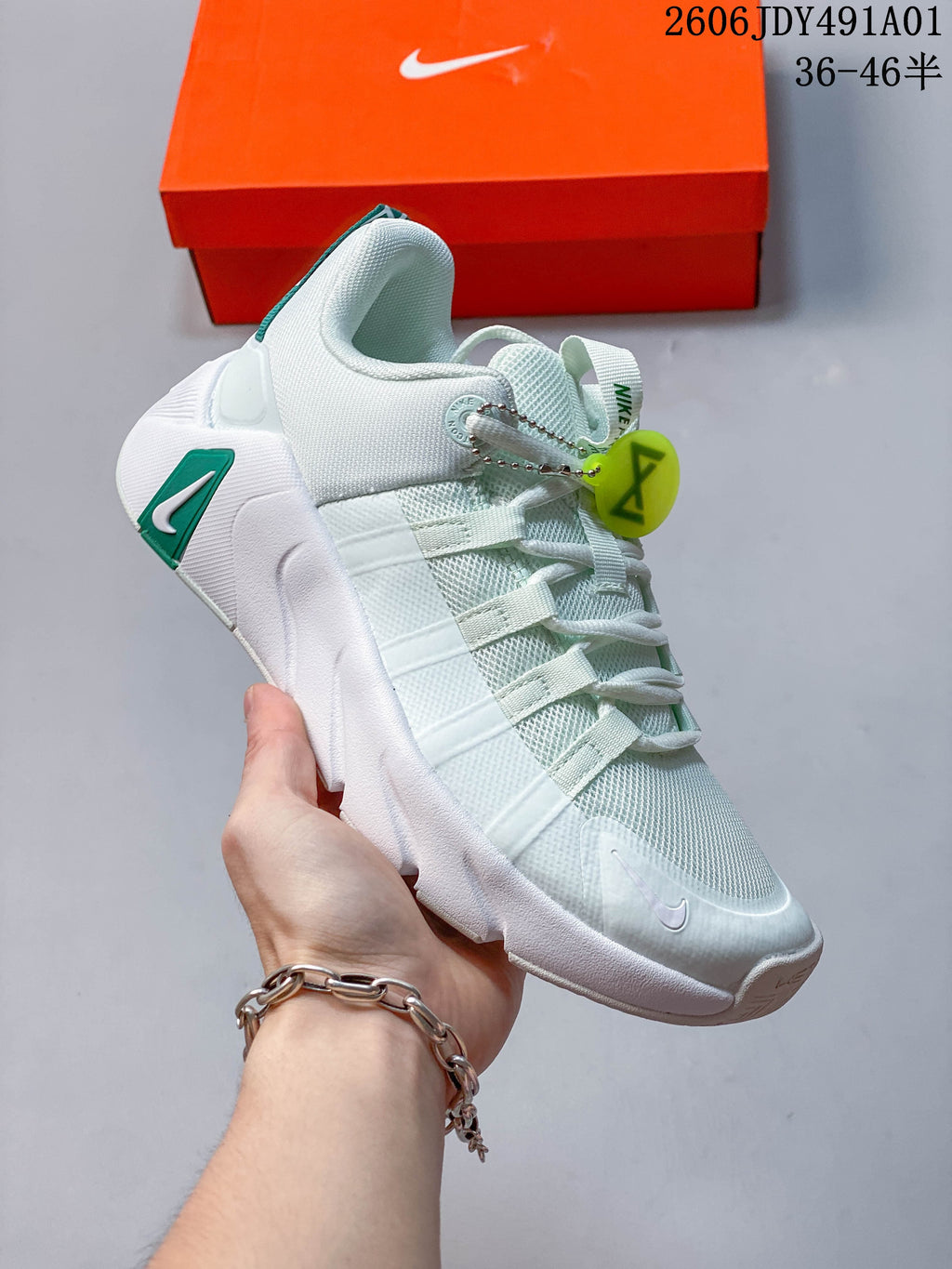 Angled side view of the white and green training shoe.