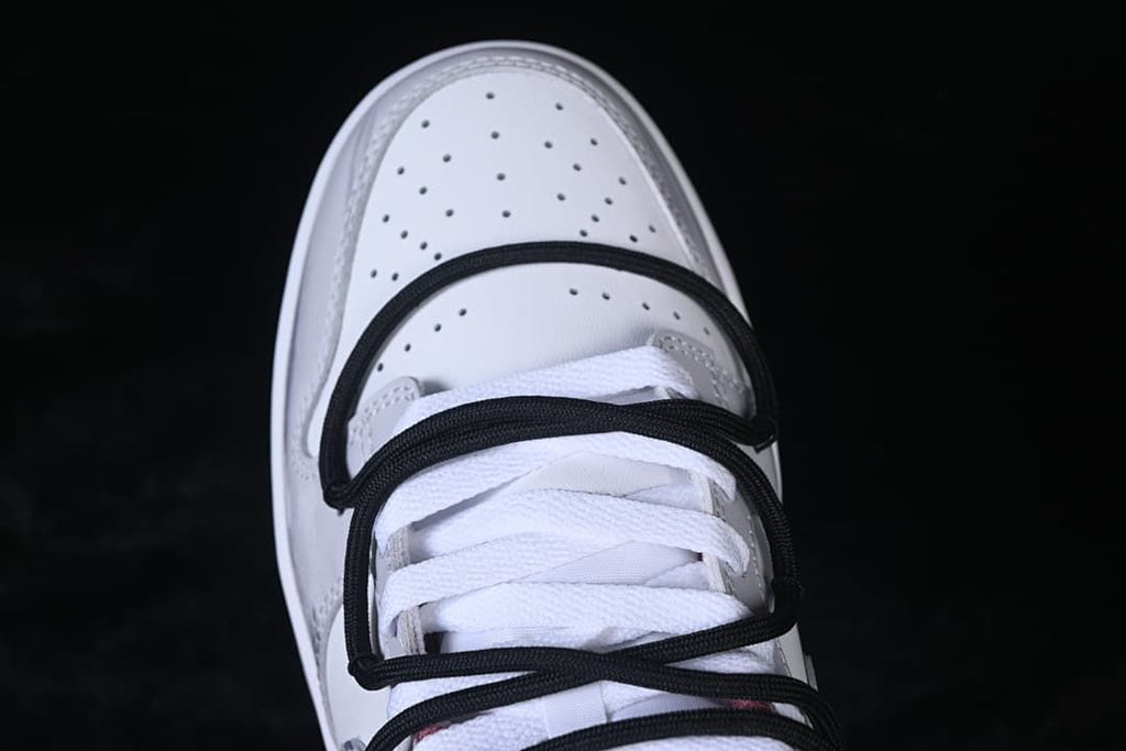 Top view of perforated toe box and black cord-style straps over white laces