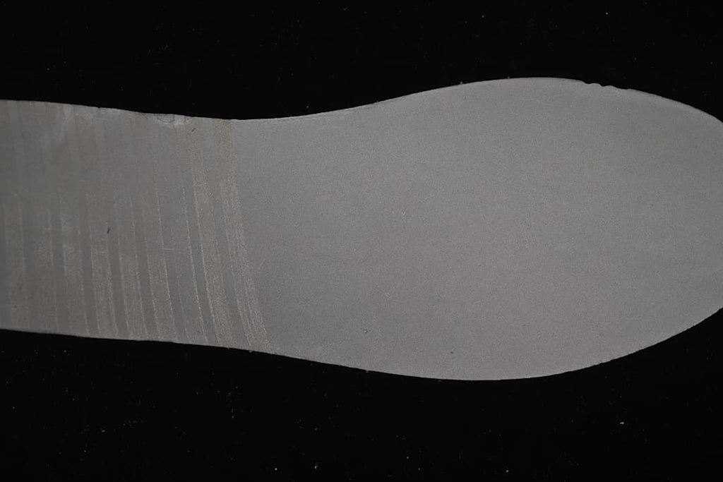 Gray shoe insert shown against a dark background