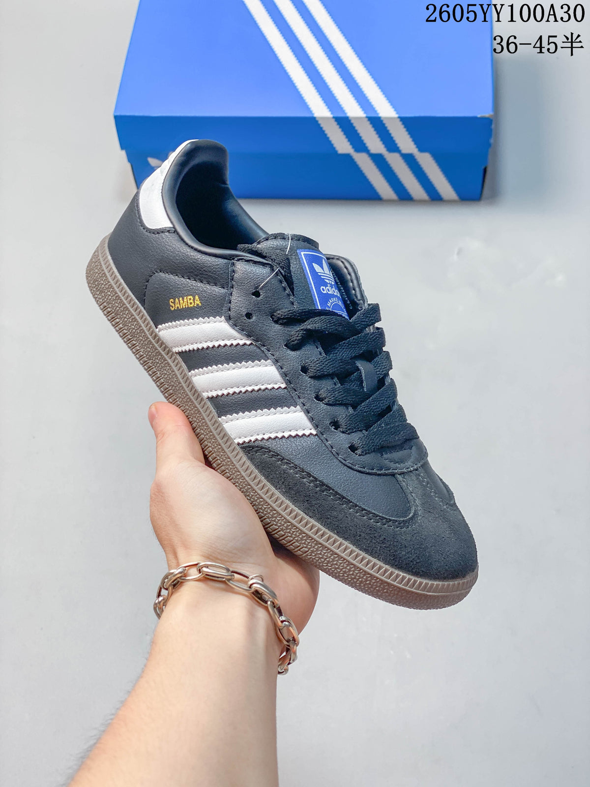 Side view of a dark grey Adidas Samba sneaker with light stripes and a gum-look outsole