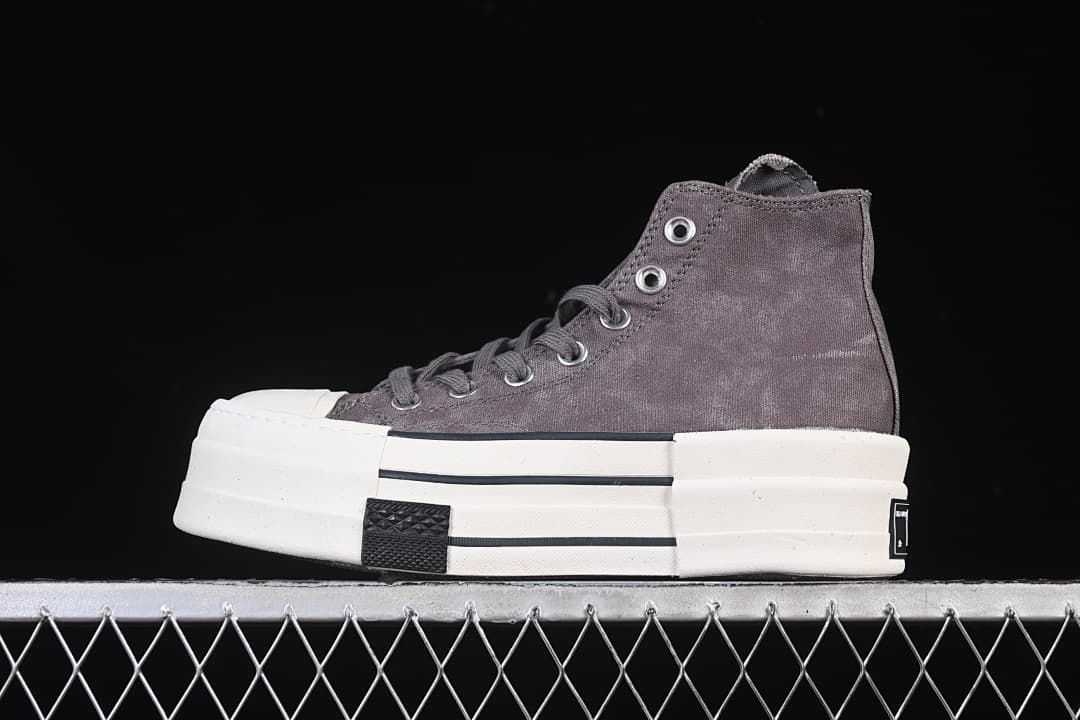 Side view of a charcoal-gray high-top sneaker with a layered light-colored sole.