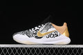 Side view of a white, black, and gold Nike Kobe 5 Protro basketball shoe with graphic lettering