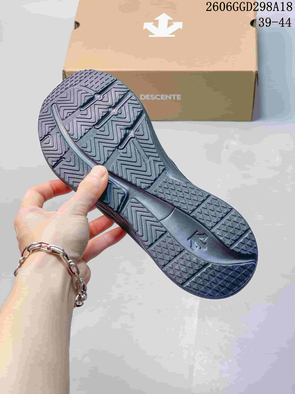 Close-up of the patterned outsole on a dark gray Descente sneaker