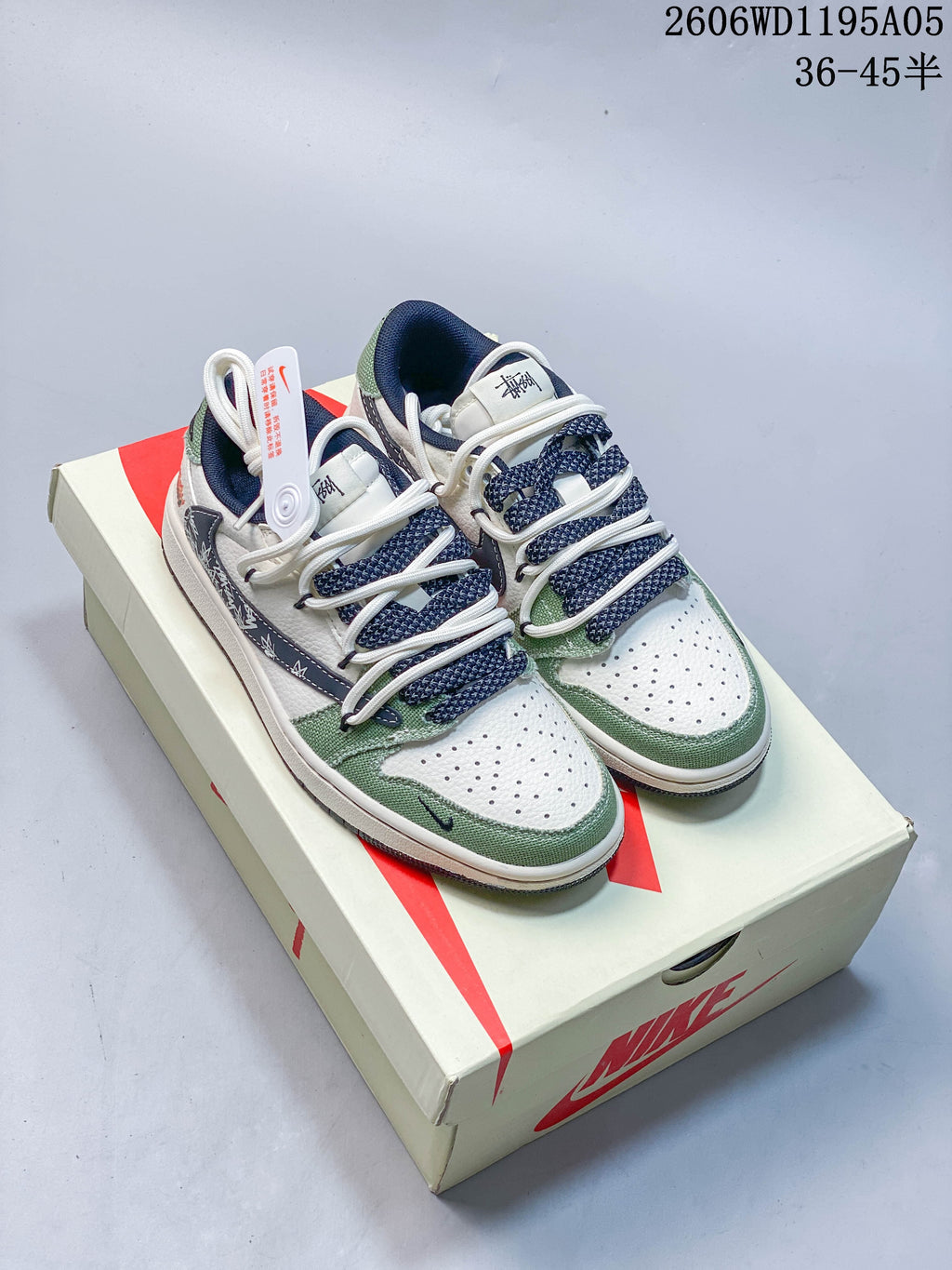 Pair of white, green, and navy low-top sneakers displayed on a branded box