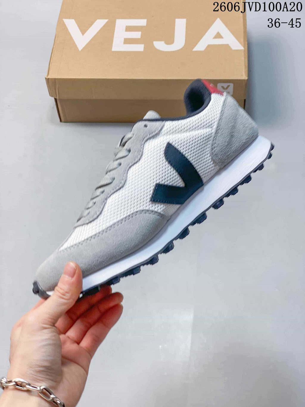 Side view of a white and grey low-top sneaker with a navy V detail; image overlay reads 36–45.