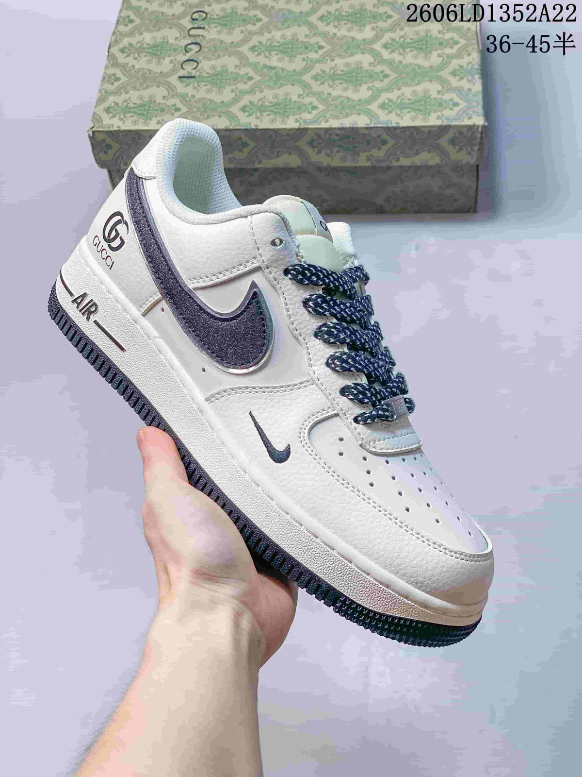 White low-top sneaker with navy accents, patterned laces and glitter-effect Swoosh.