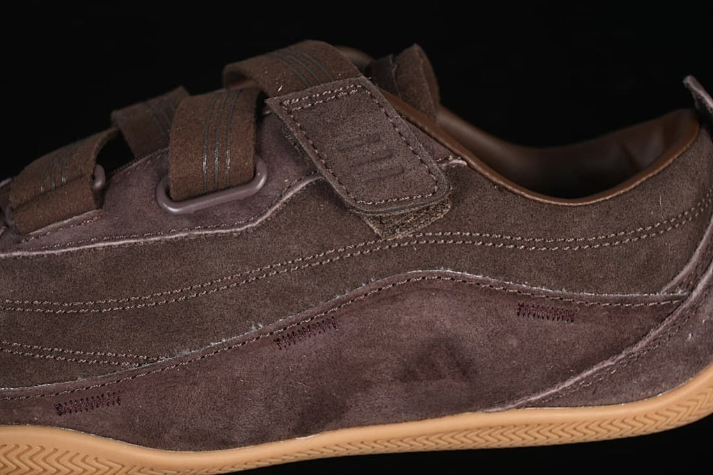 Side detail of the brown upper, stitching, and hook-and-loop strap.
