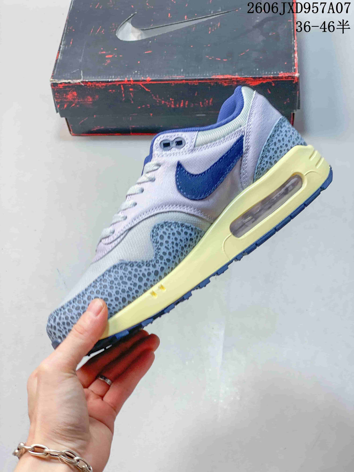Side profile showing the blue Swoosh, patterned overlays, cream midsole, and heel Air window.