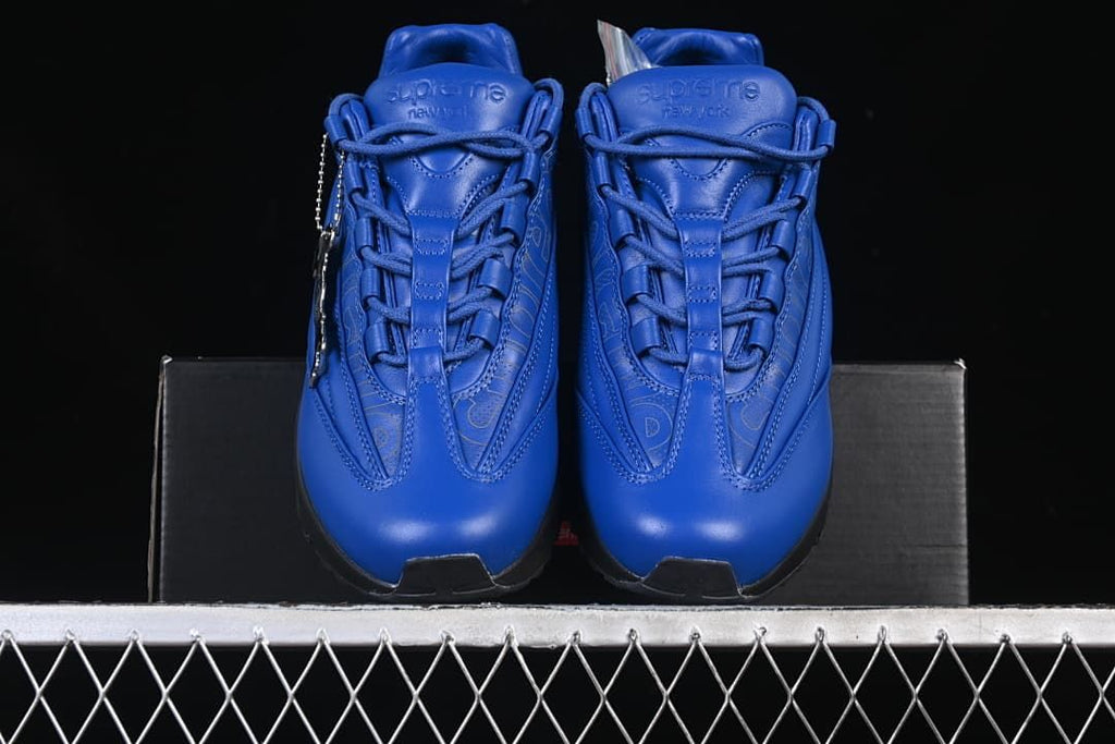 Front view of the pair showing blue uppers, laces, and Supreme tongue branding.