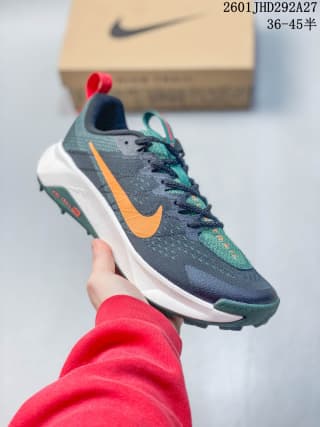 Dark gray Nike trail running shoe with an orange Swoosh, green details, and a contrasting outsole.