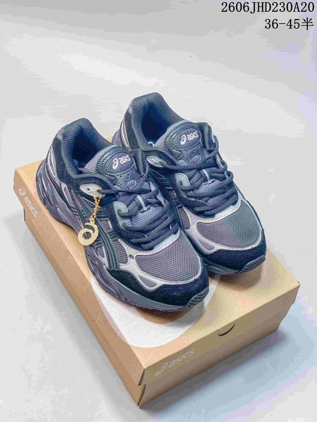Pair of navy and silver ASICS GEL-NYC 2 sneakers displayed on a shoebox
