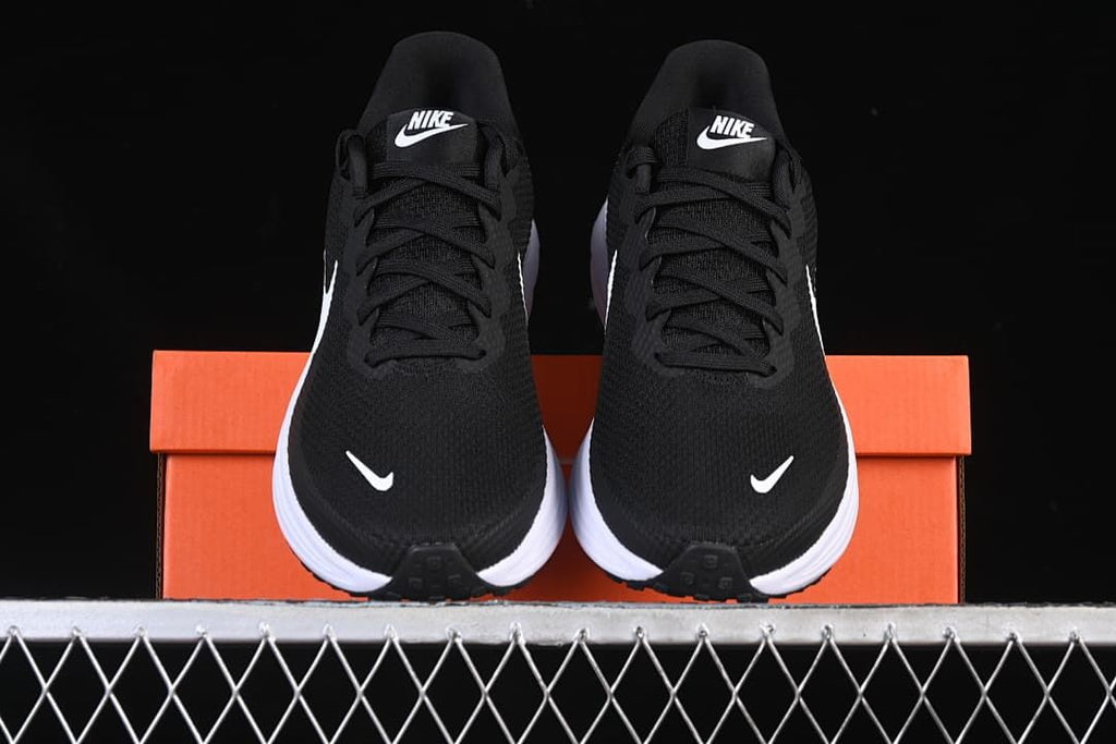 Front view of the pair of black running shoes displayed on an orange box