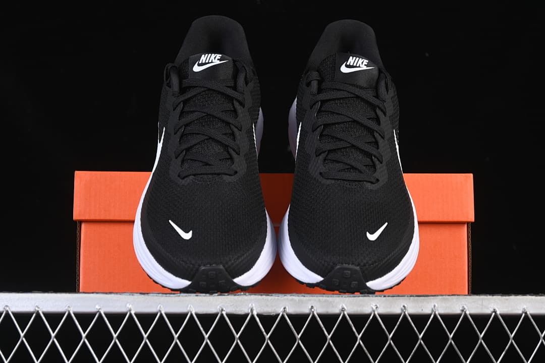 Front view of the pair of black running shoes displayed on an orange box