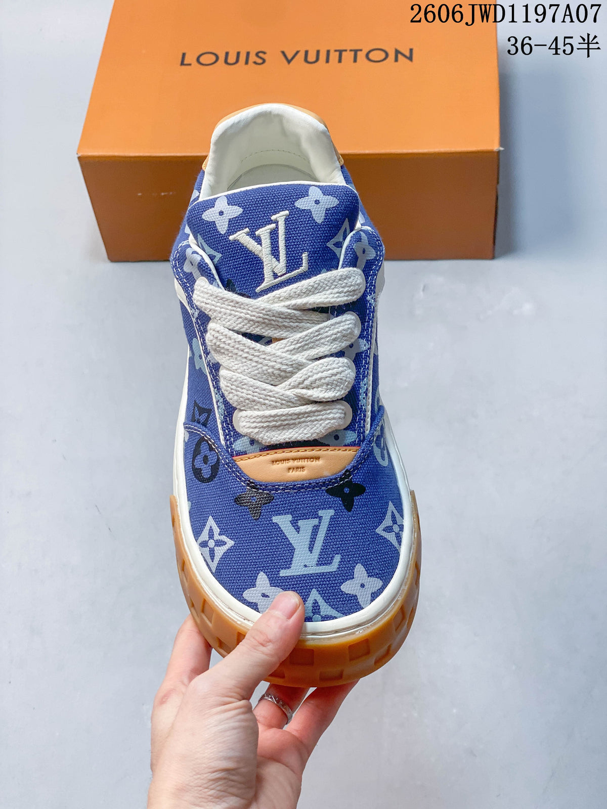 Front view highlighting the white laces, blue patterned upper, and tan accent panel