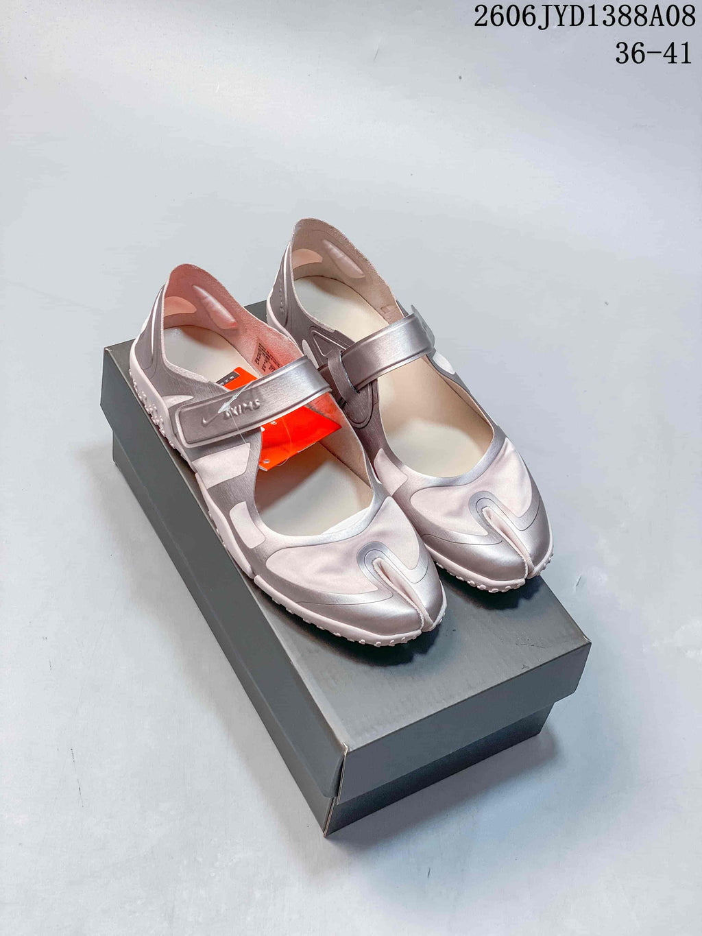 Pair of pink and metallic-toned Nike Air Rift shoes on a box