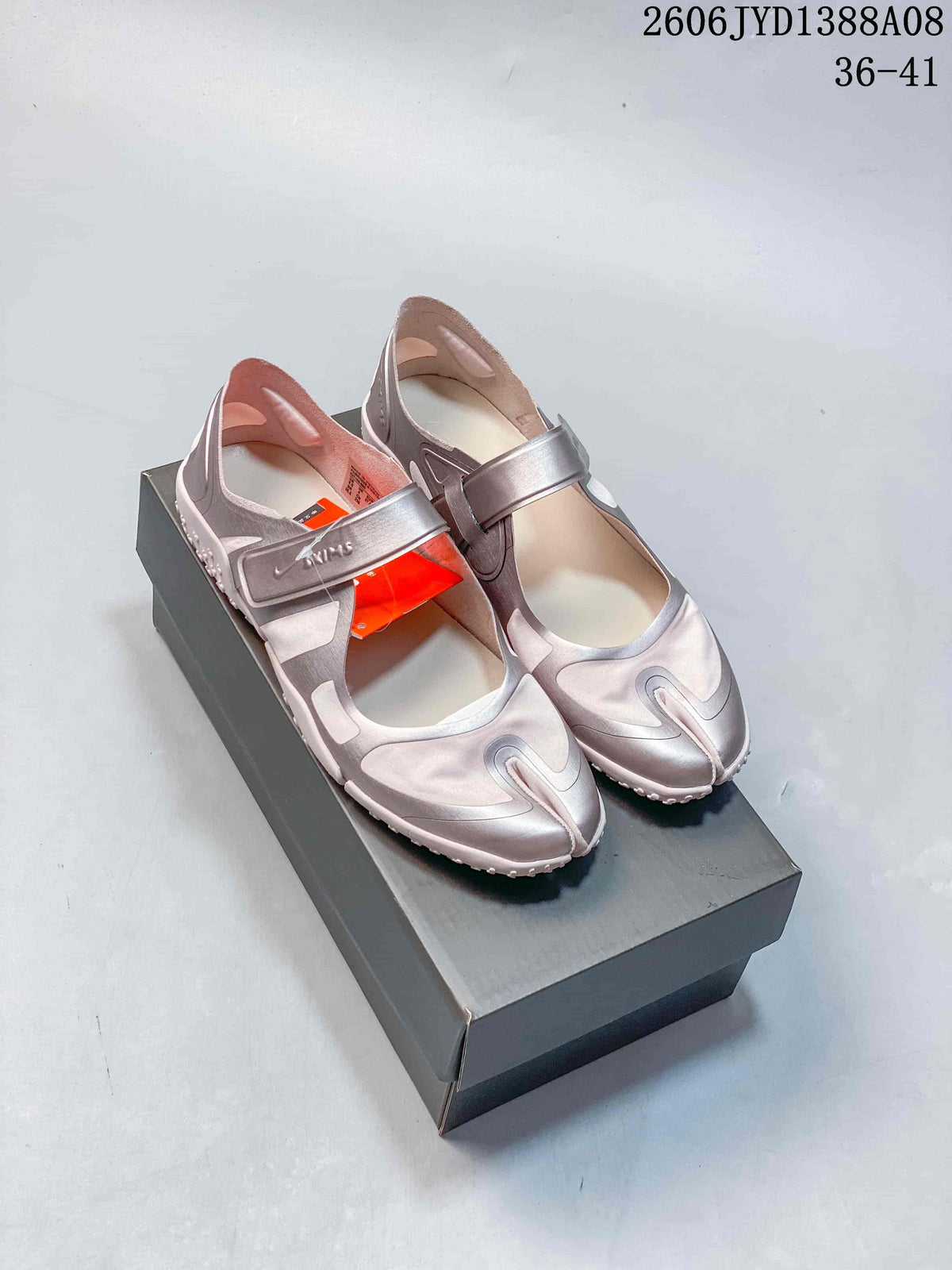 Pair of pink and metallic-toned Nike Air Rift shoes on a box