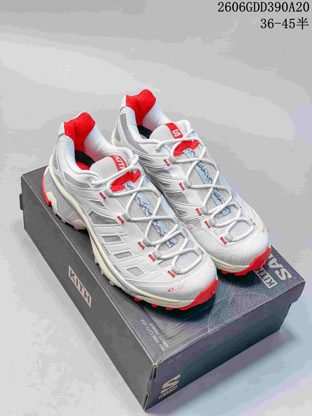 White Salomon XT-4K trail shoes with red accents displayed on a Kith-branded box