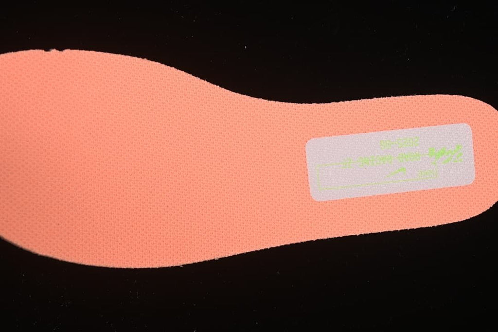 Close-up of the coral-orange textured insole and printed label.