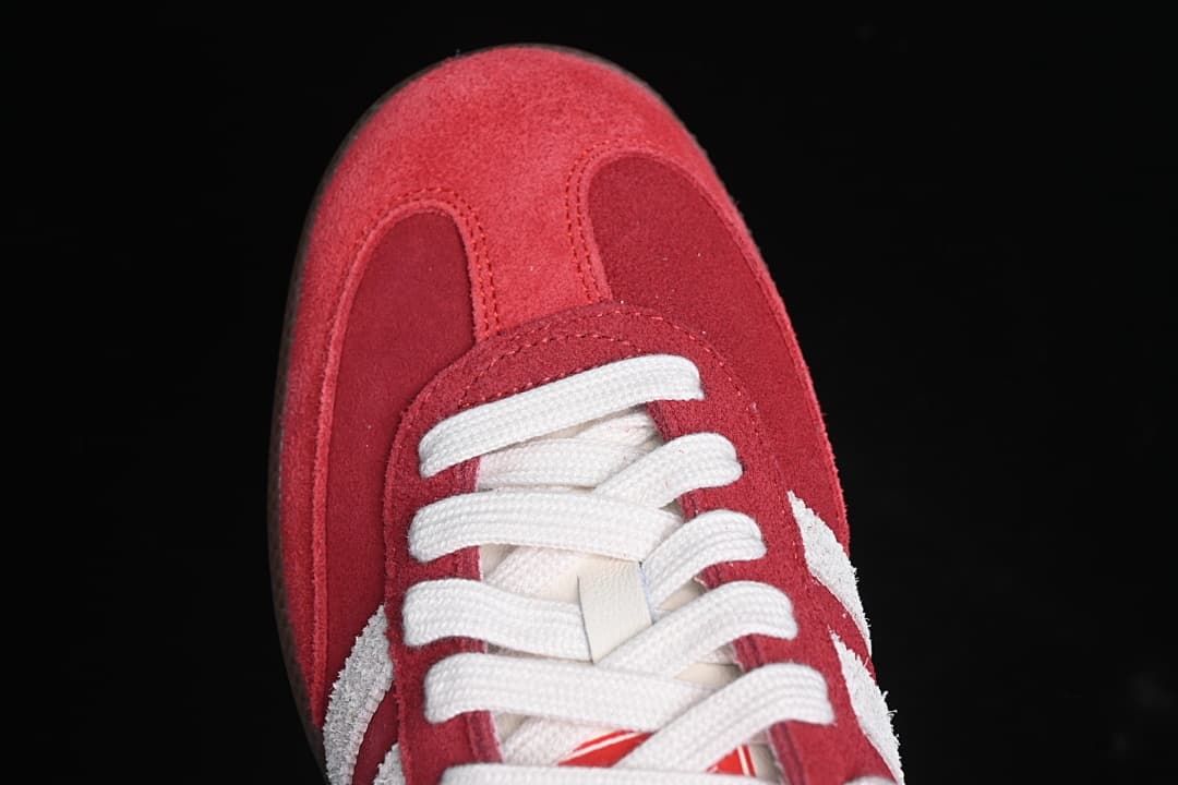 Top-down close-up of the red toe and white laces.