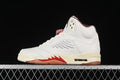 Side view of a light-colored Air Jordan 5 sneaker with burgundy details and gum-toned outsole