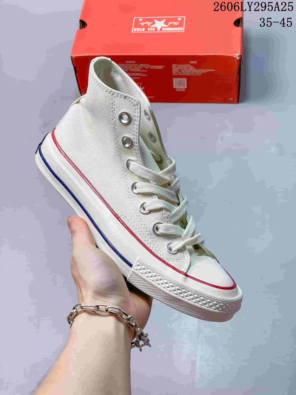 Off-white Converse high-top lace-up sneaker with a white toe cap and red and blue sole accents