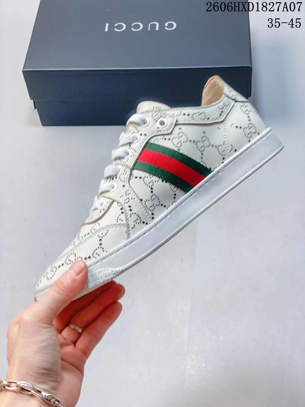 Side profile of white perforated sneaker with green-and-red stripe and white sole