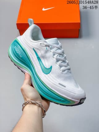 White Nike Vomero Plus shoe with teal swoosh and teal sole accents.