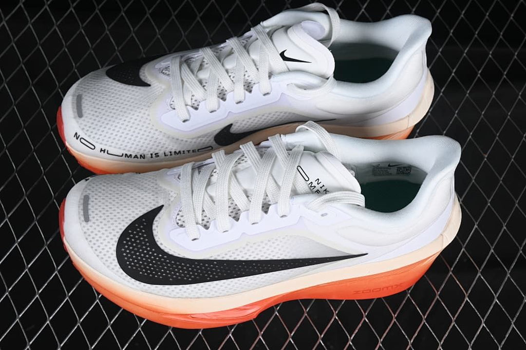 Pair of white Nike running shoes with black Swooshes and coral-orange soles