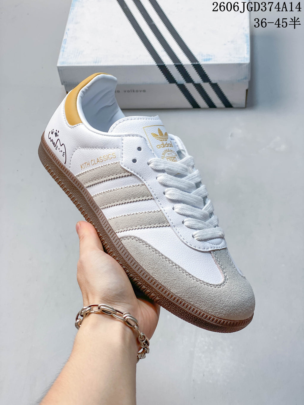 Close-up of a white low-top sneaker with beige stripes, suede-look toe overlay, and gum sole.