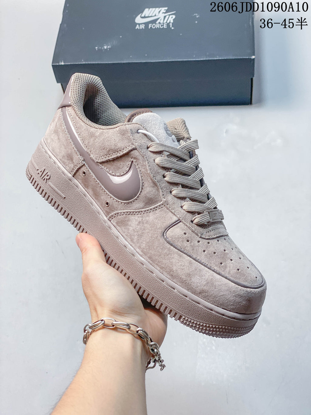 Light gray Nike Air Force 1 sneaker shown from the side with a perforated toe and tonal Swoosh.