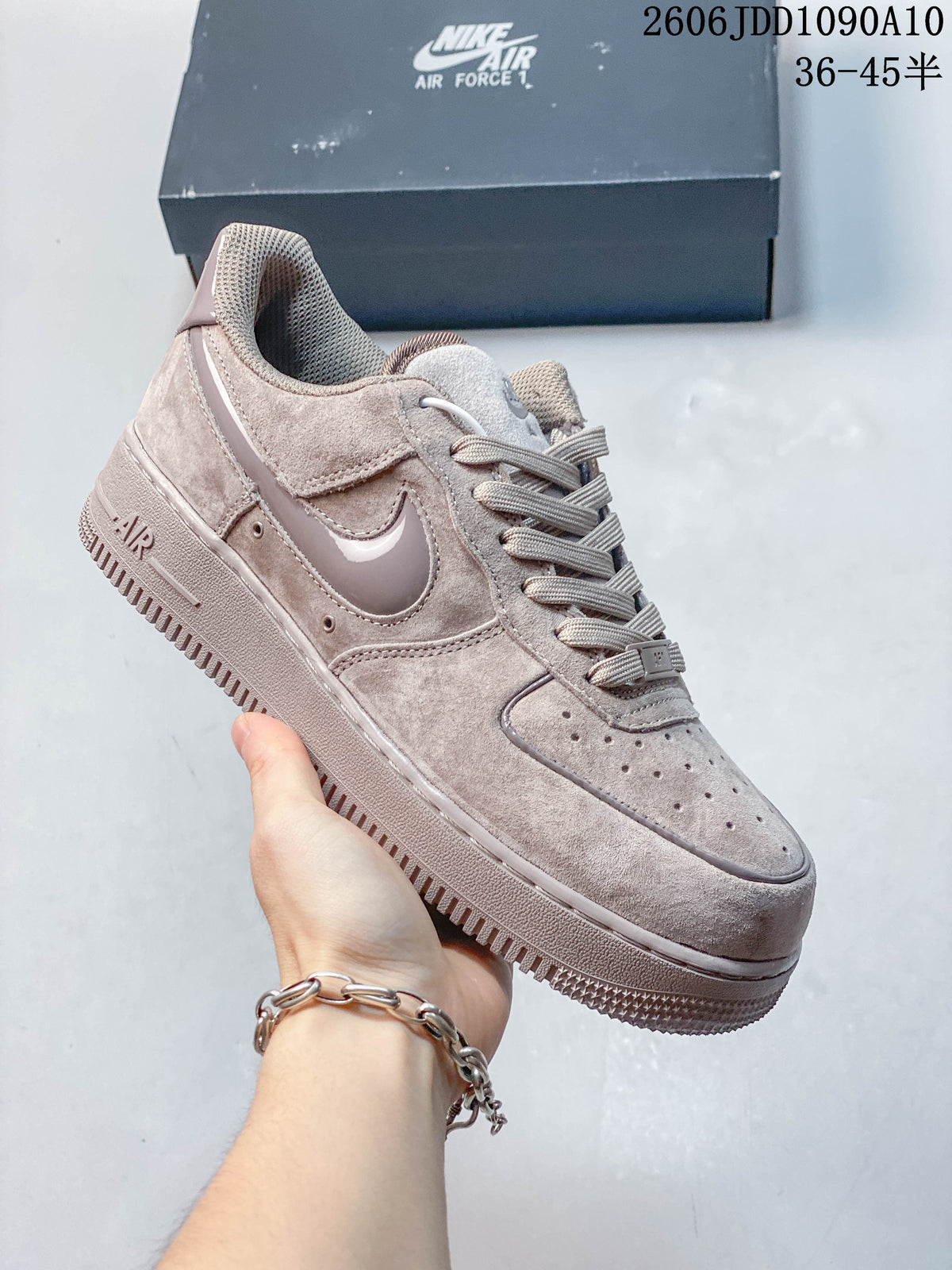 Light gray Nike Air Force 1 sneaker shown from the side with a perforated toe and tonal Swoosh.