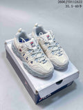 Pair of white and gray FILA Muffin low-top sneakers on a shoe box