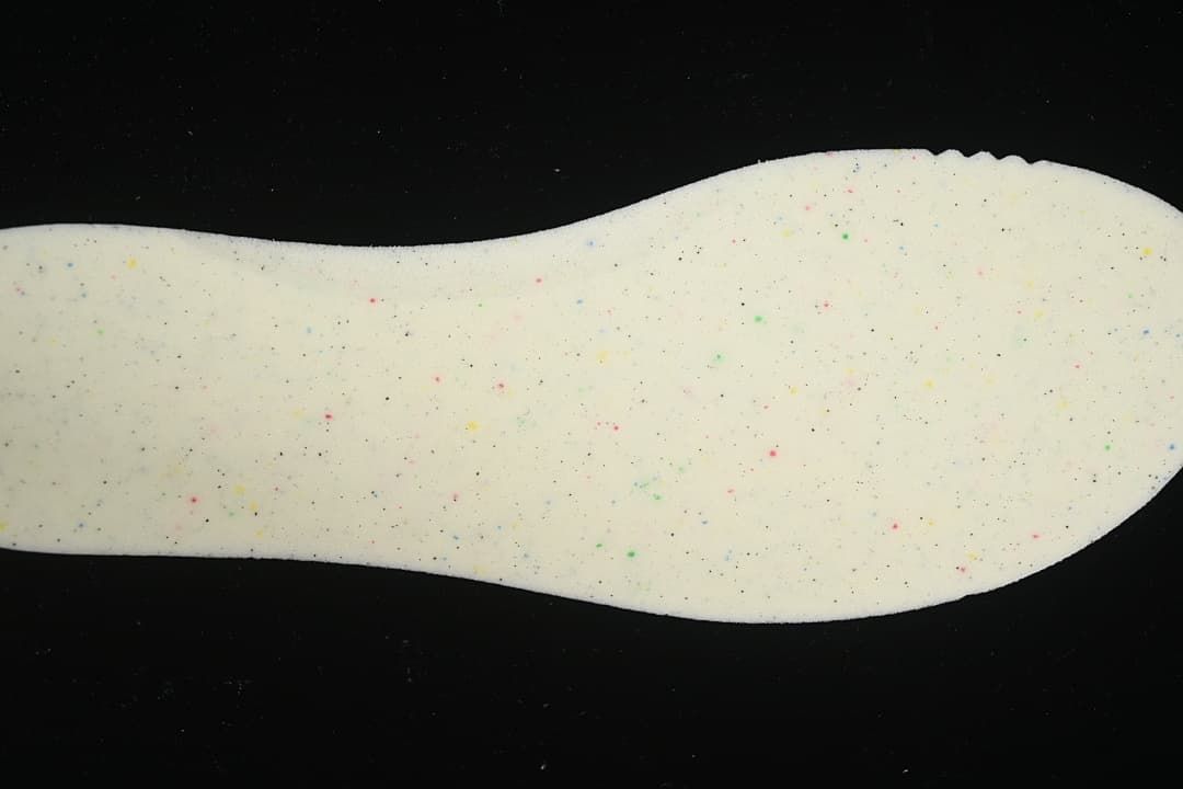 Close-up of light-colored shoe insert with multicolor speckles