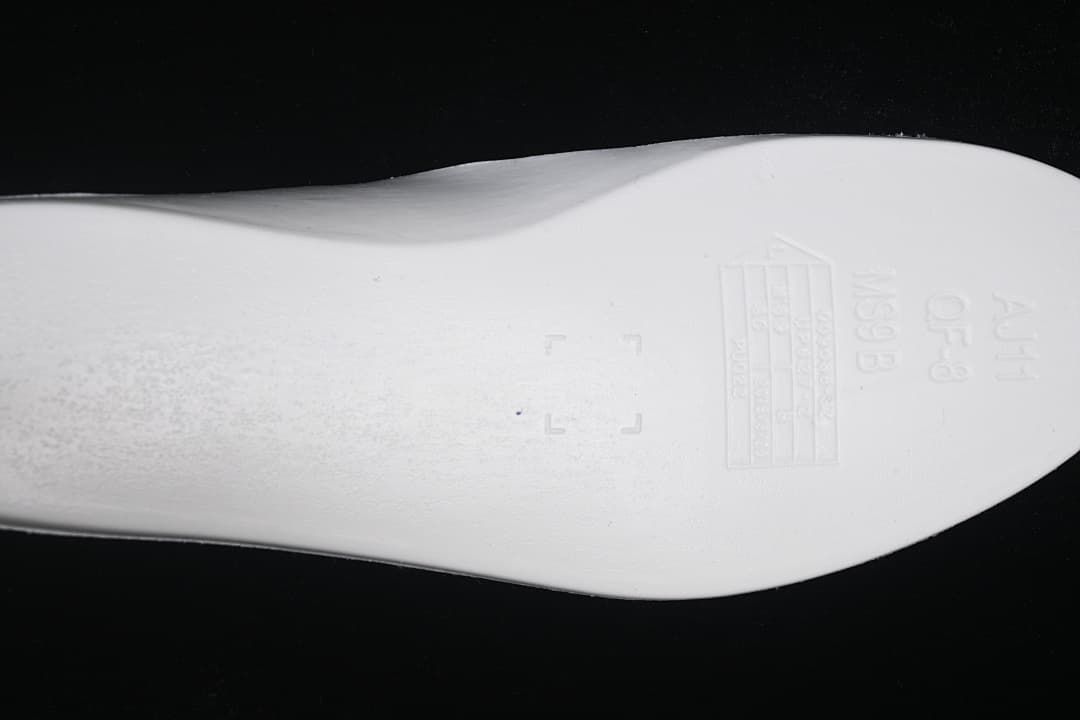 Close-up of the sneaker outsole with embossed markings.
