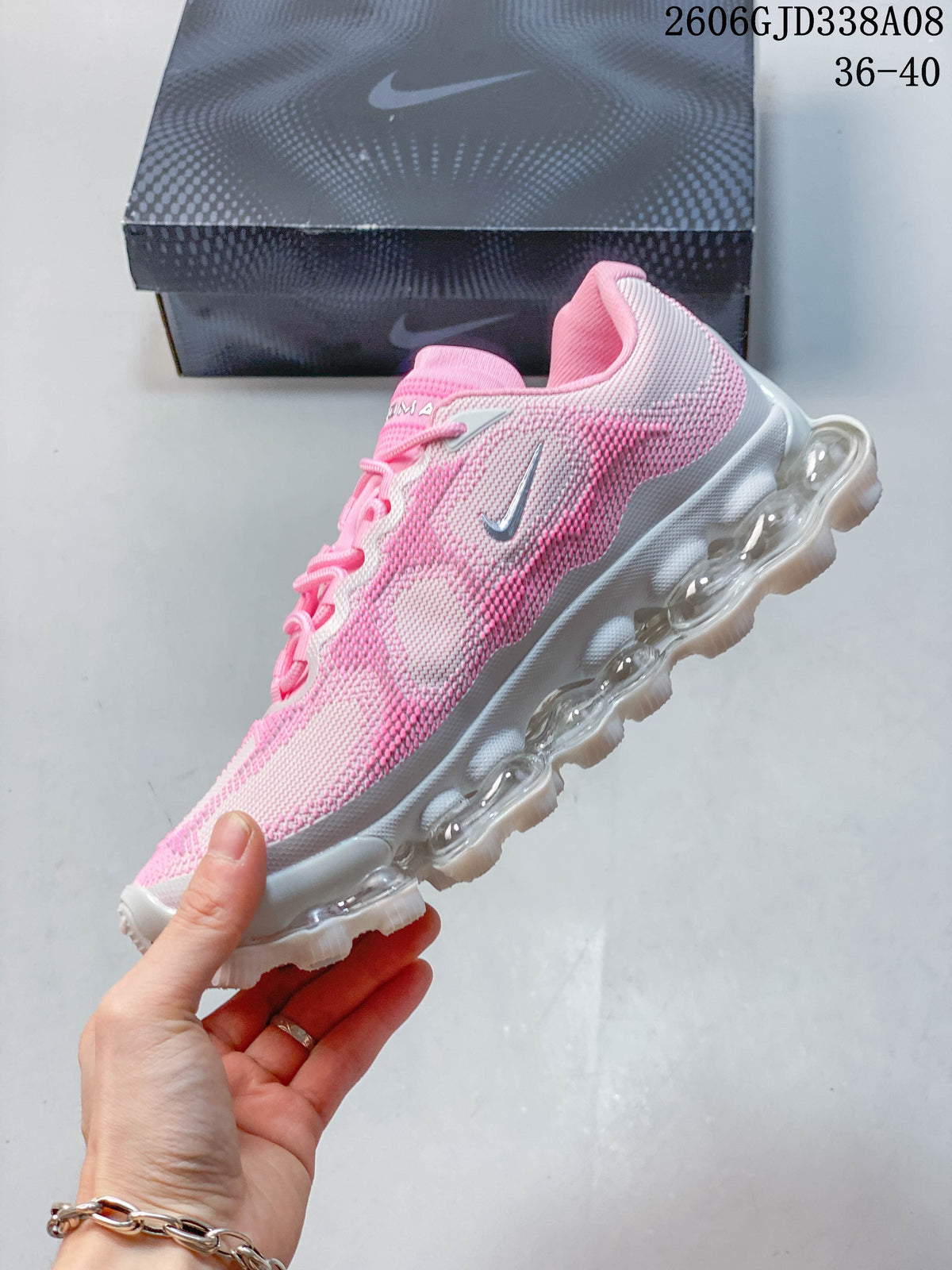 Side view of the pink and light gray sneaker with visible cushioning pods.