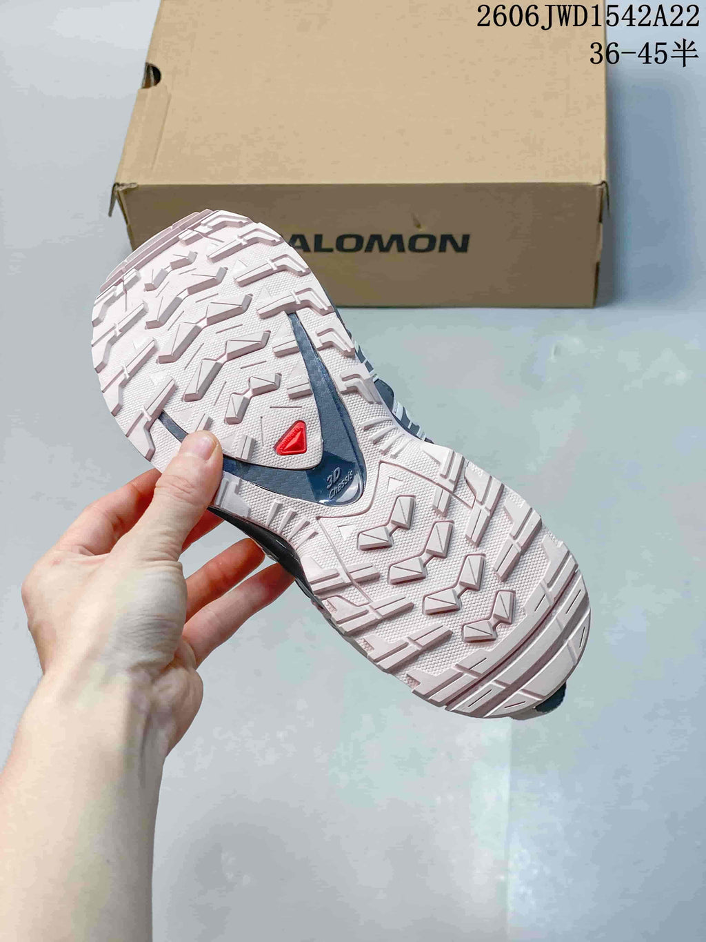 Close-up of the patterned outsole on a Salomon trail-style sneaker