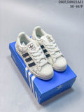 White Adidas Superstar sneakers with dark stripes and outlined star graphics, shown on a blue shoe box.