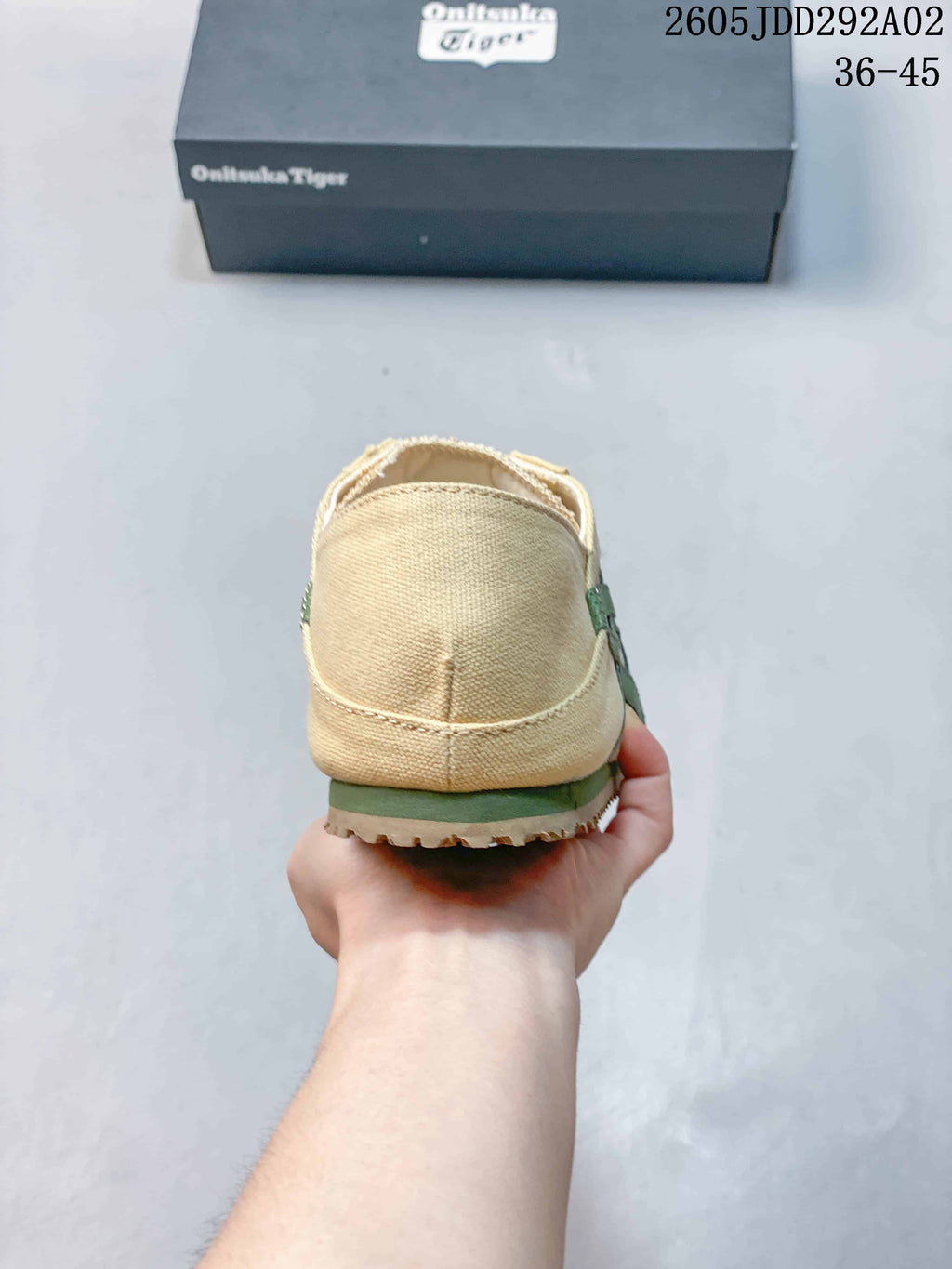 Rear view of the beige slip-on sneaker with green outsole trim.