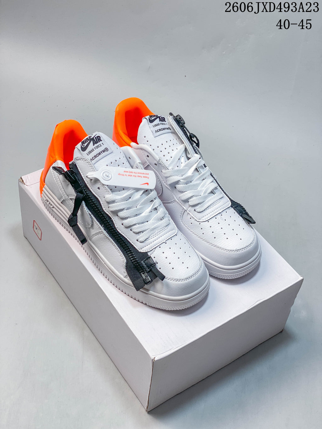 White low-top sneakers with dark zipper details and bright orange lining
